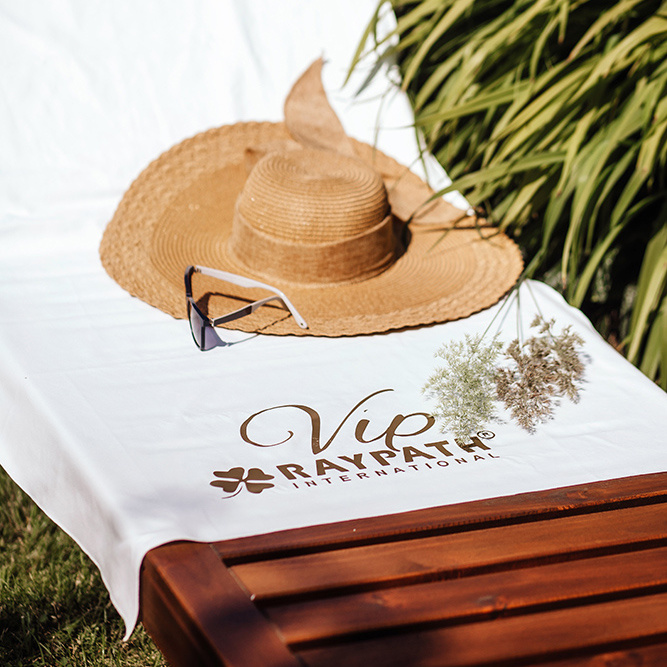 Biały ręcznik Sunbeam VIP Raypath na leżaku w ogrodzie